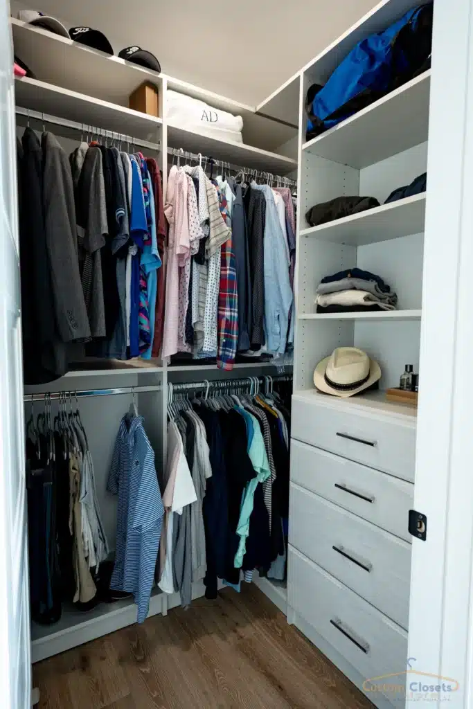 small gray walk-in closet with drawers and hanging space