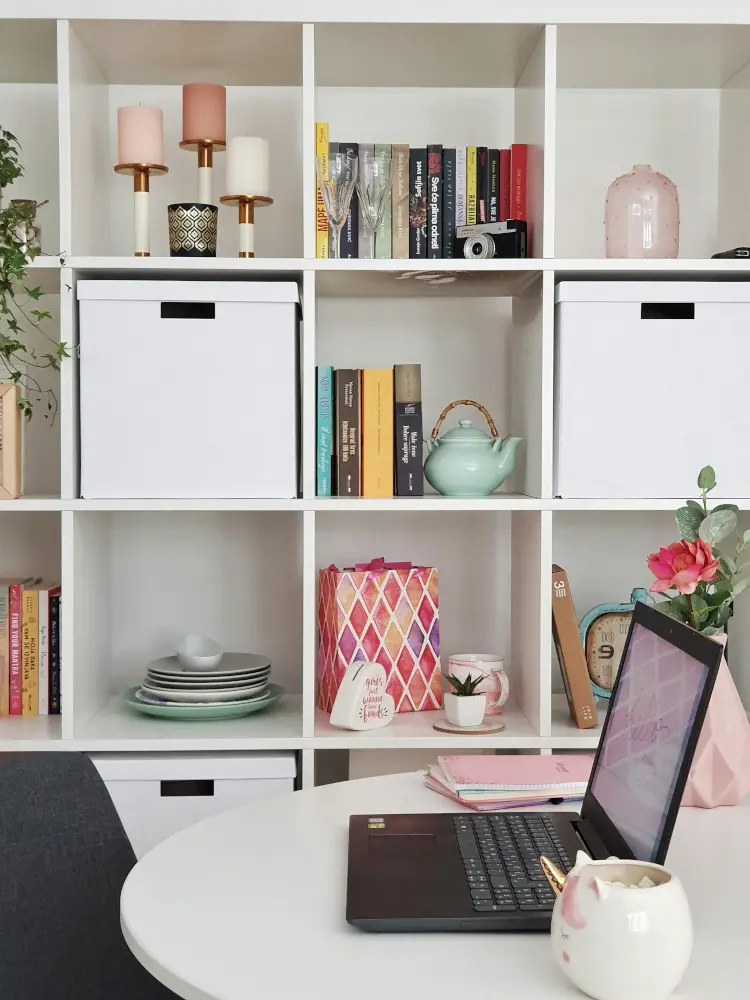 white round office desk with open shelfing on the side, storing books, candles and decorations